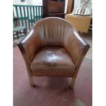 A brown leather tub chair