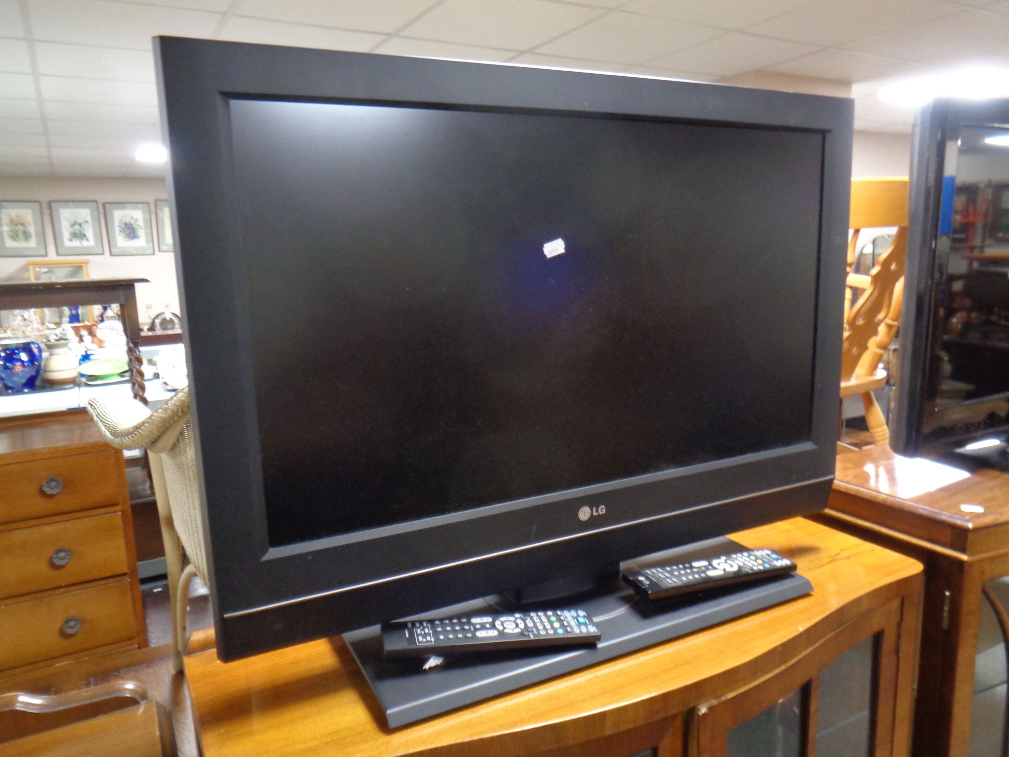 An LG 32'' LCD TV with two remotes
