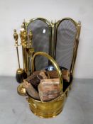 A four piece brass companion set on stand together with a brass swing handled coal bucket and a