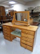 A pine ten drawer dressing table with mirror and stool