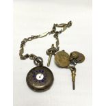 A vintage silver pocket watch with white metal chain and key with fob