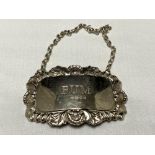 A silver decanter label,