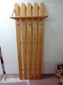 A pine wall mounted coat rack with shelf
