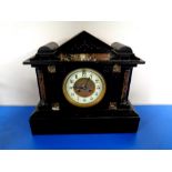 An antique black slate and marble mantel clock