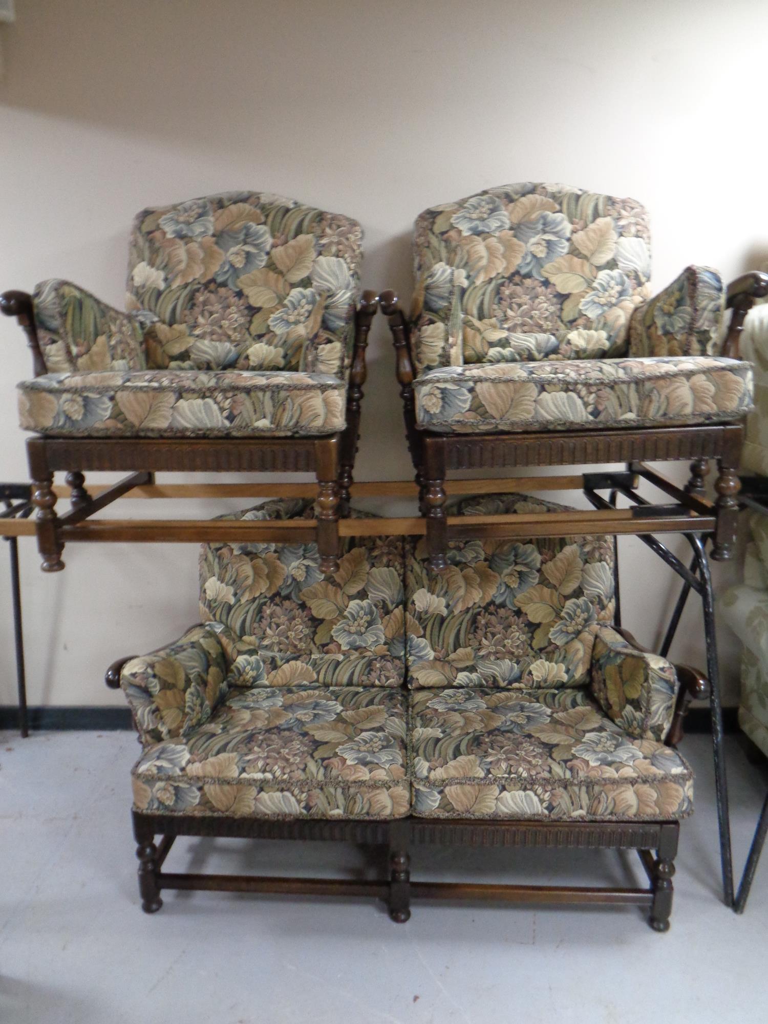 A three piece Ercol cottage suite upholstered in a tapestry fabric in an antique finish