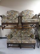 A three piece Ercol cottage suite upholstered in a tapestry fabric in an antique finish