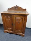 A 20th century carved oak double door cabinet