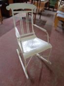 An early 20th century wrought iron and wood painted rocking chair