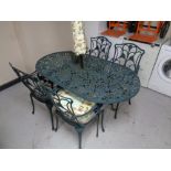 A cast metal patio table together with four matching armchairs, parasol,