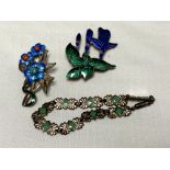 A collection of silver and enamelled brooches