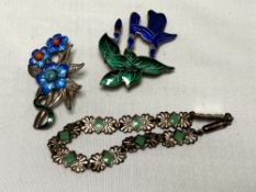 A collection of silver and enamelled brooches