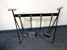 A cast iron four piece companion set on stand