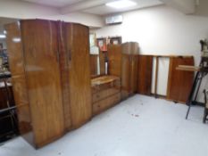 A four piece 20th century walnut bedroom suite comprising of lady's and gent's wardrobe,