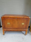 A yew wood campaign style cocktail cabinet on casters