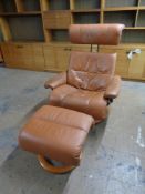 A Stressless brown leather reclining armchair with footstool