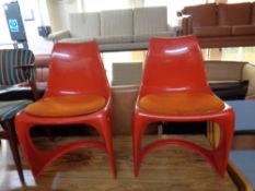 A pair of 1970s moulded plastic dining chairs with cushions