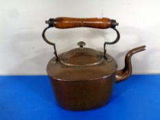 A 19th century copper kettle with wooden handle