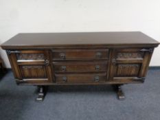 An oak old charm double door low sideboard fitted three central drawers,