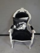 A contemporary painted salon armchair upholstered in a black fabric with Marilyn Monroe cushion