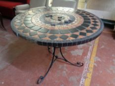 A tile topped mosaic patio table on metal pedestal