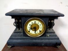 An antique ebonised mantel clock with brass and enamel dial