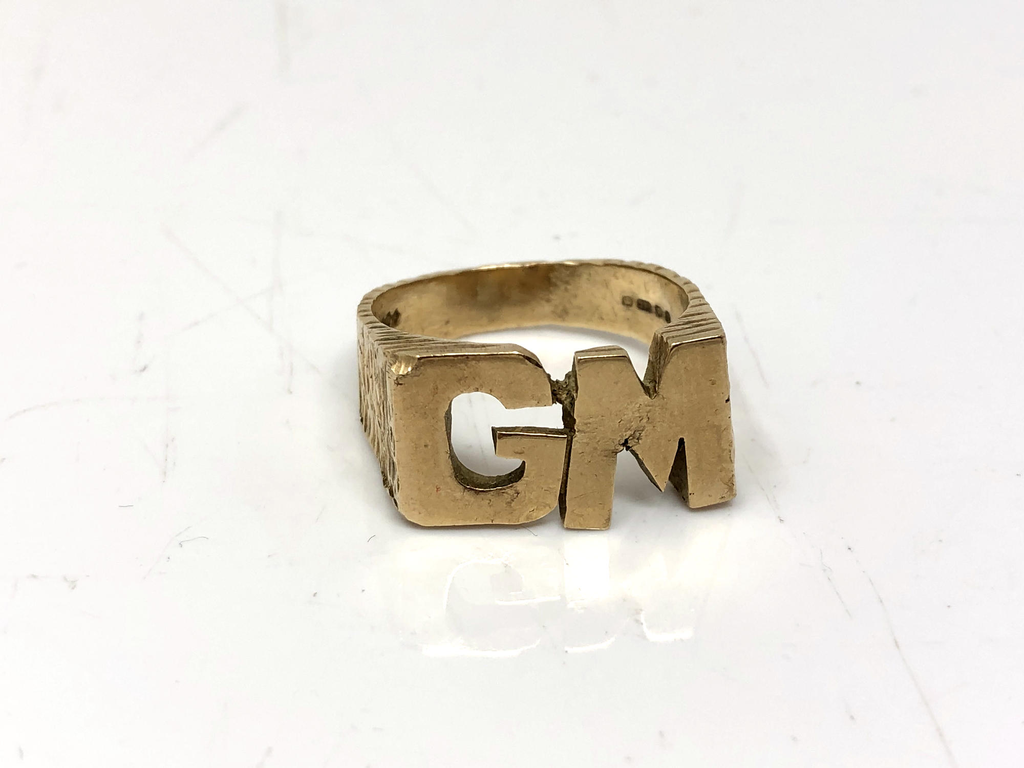 A 9ct gold ring with initials GM, size V. CONDITION REPORT: 9.