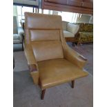 A 1970s Danish armchair upholstered in a brown vinyl on teak legs,