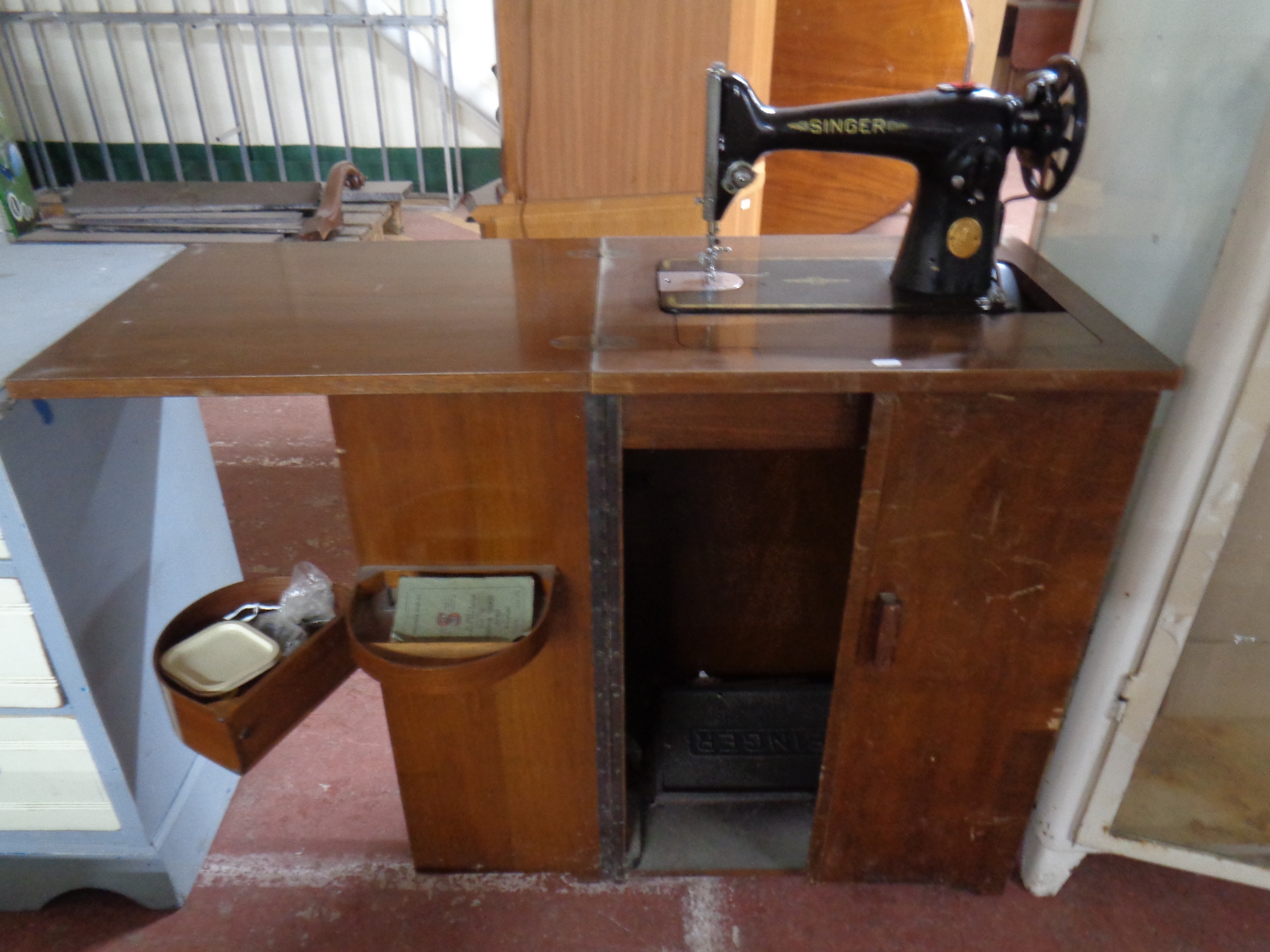 A 20th century Singer treadle sewing machine in cabinet