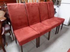 A set of six contemporary high backed dining chairs upholstered in a red suede fabric
