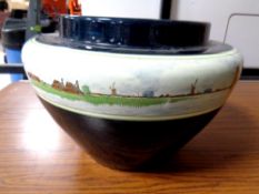 A glazed pottery planter depicting Dutch windmill scenes