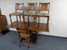 A 20th century oak pull out dining table together with a set of four panel back chairs