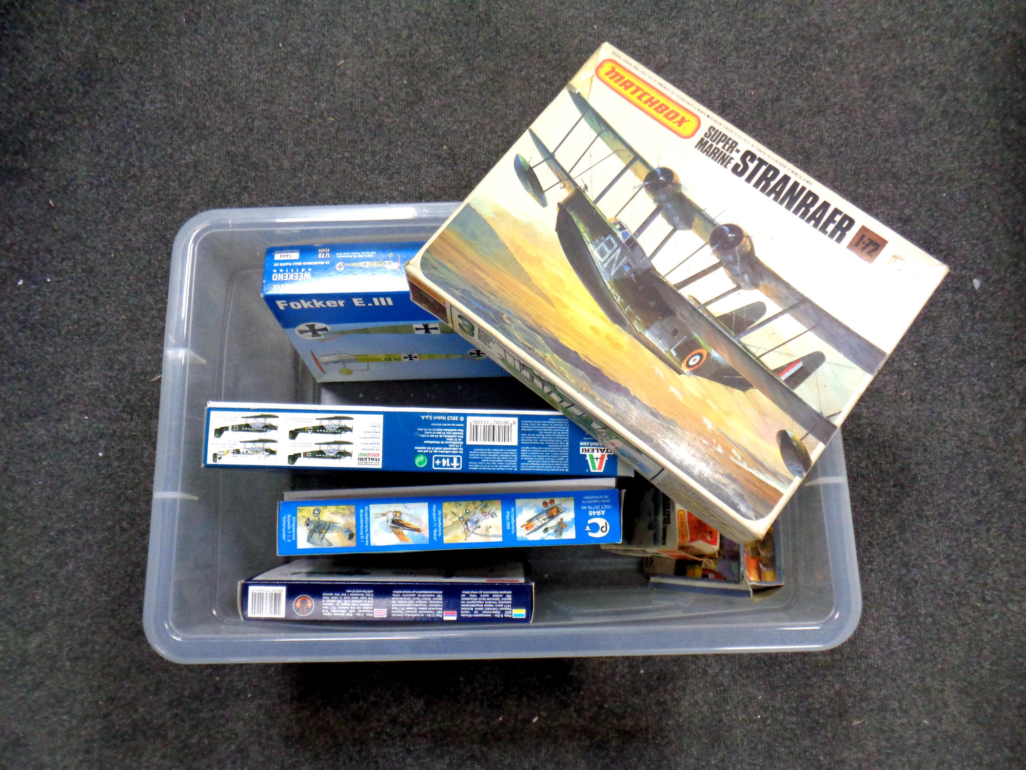 A plastic storage crate with lid containing modelling kits by Italeri,