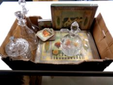 A box containing a cut glass lidded biscuit barrel together with three glass decanters with