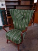 A 20th century beech framed wingback armchair upholstered in a striped fabric