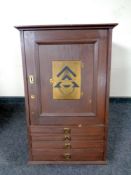 An early 20th century single door cabinet fitted four drawers beneath bearing Freemason's brass