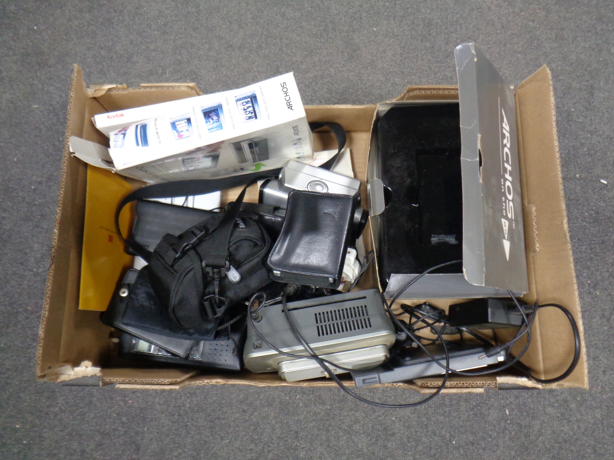 A box containing Archos DVD station, Kodak printer and digital camera,