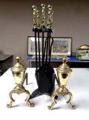 A pair of antique cast iron and brass fire dogs together with a four piece companion set on stand