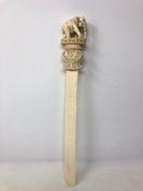 A large 19th century Indian ivory page turner with carved terminal elephant figure on stepped