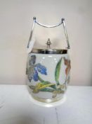 An antique silver plated and opaque glass lidded biscuit barrel decorated with foliage and