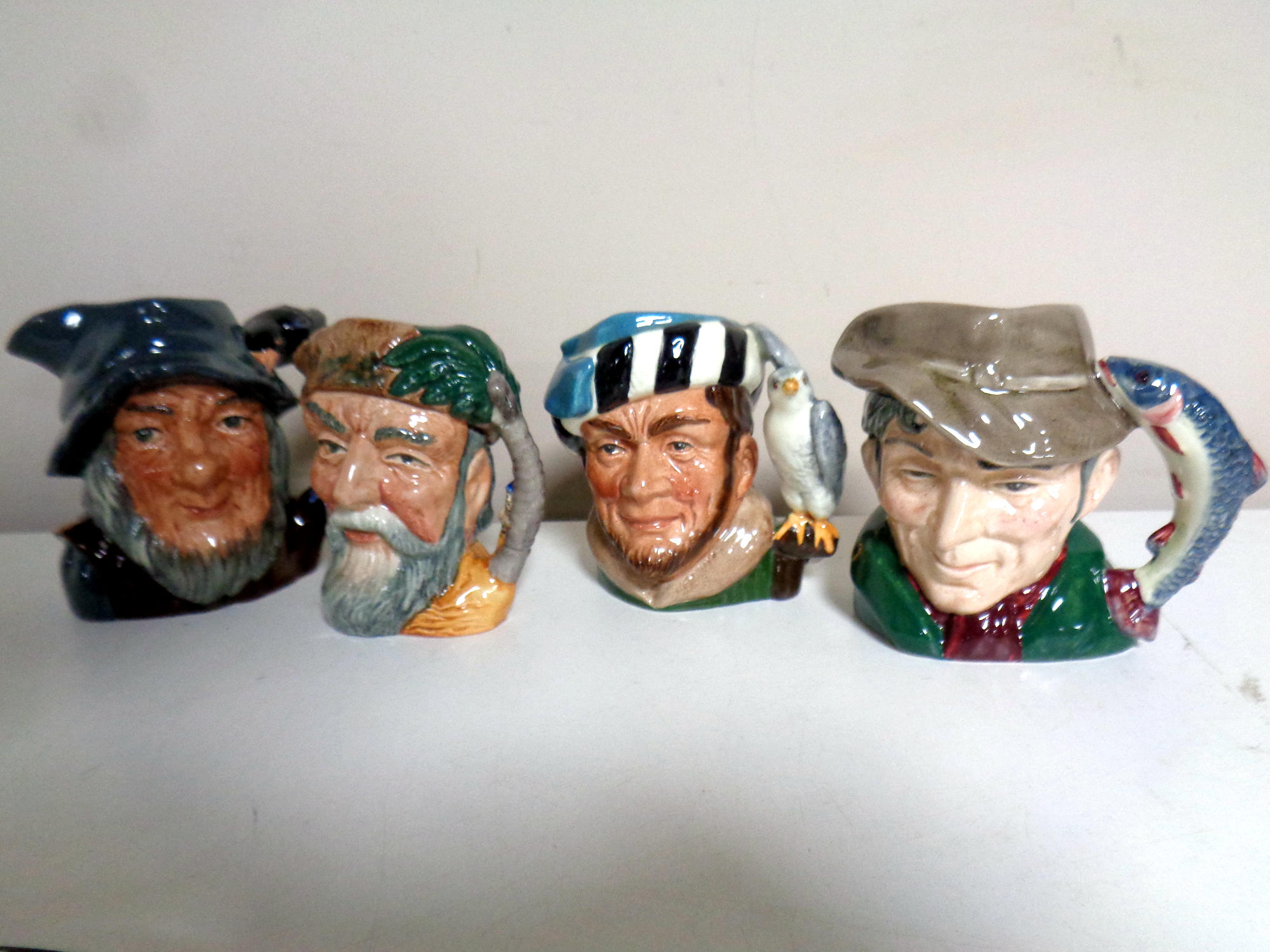 Four small Royal Doulton character jugs - The Poacher, The Falconer,
