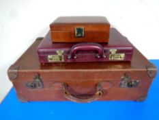 A vintage leather suitcase together with a leather briefcase and jewellery box