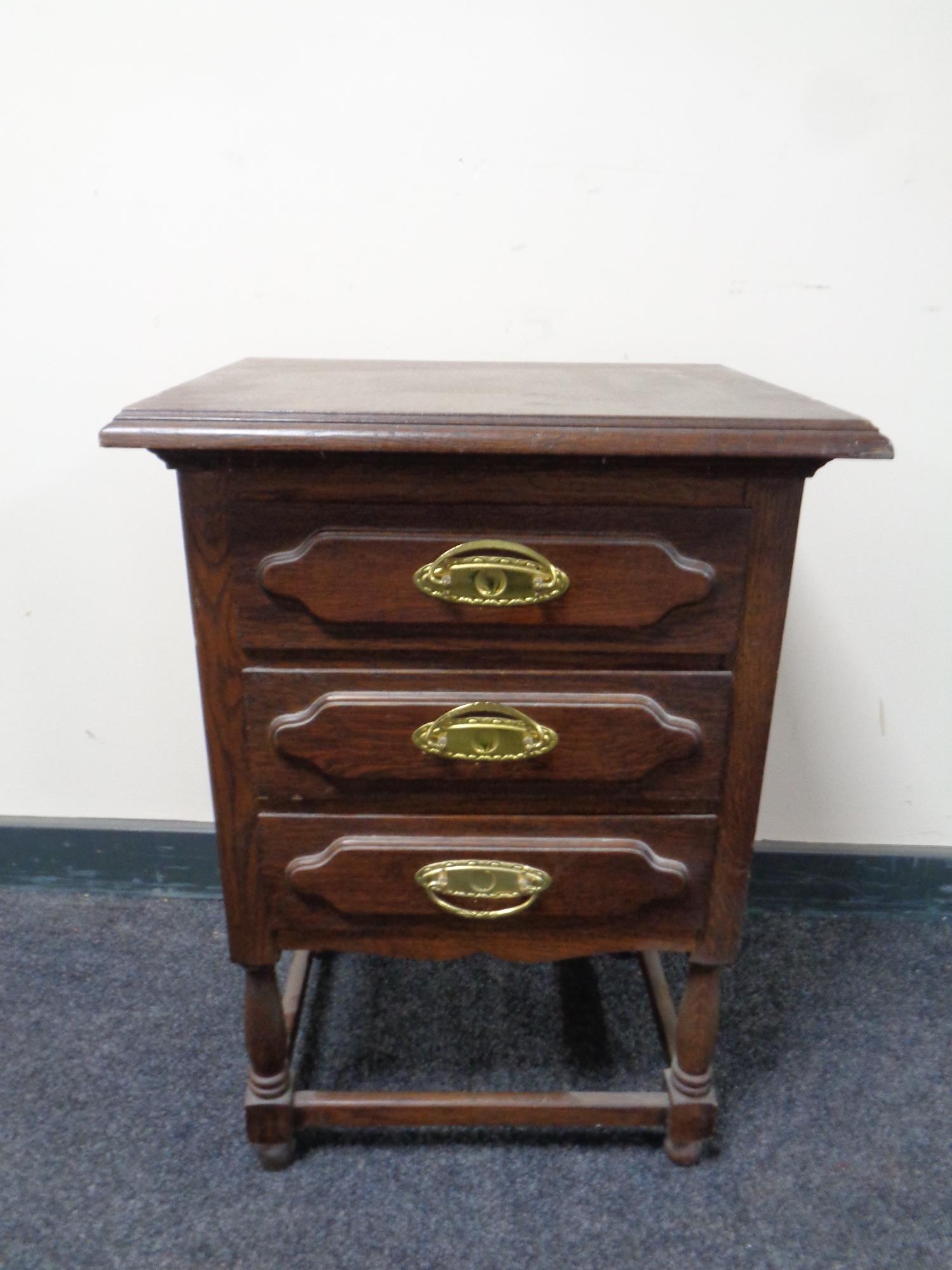 A continental oak three drawer chest with brass drop handles