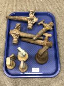 A tray of antique barrel taps and four graduated brass weights