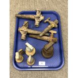 A tray of antique barrel taps and four graduated brass weights