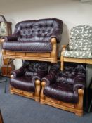 A wood framed three piece leather button back lounge suite comprising of two seater settee and two