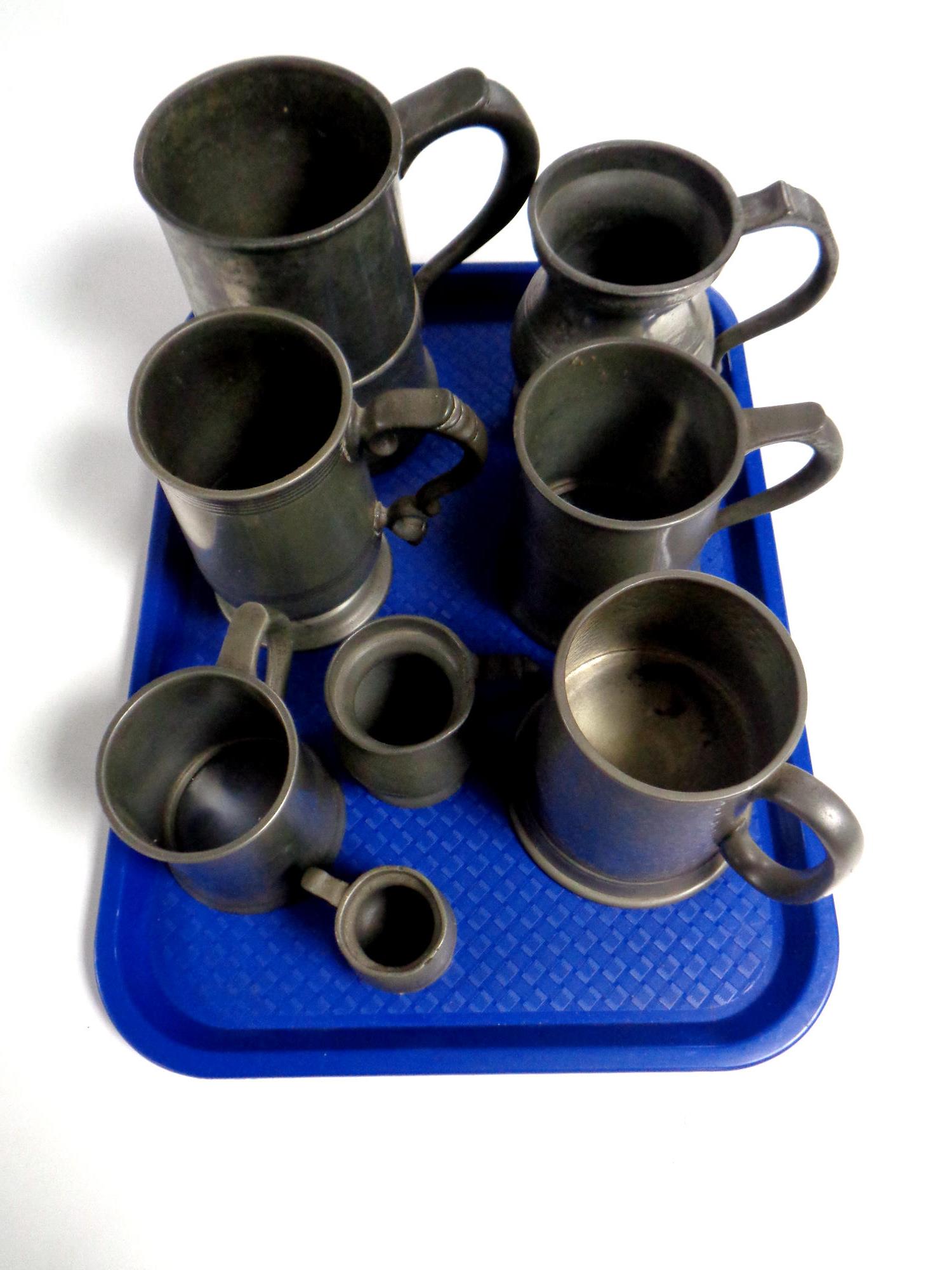 A tray containing 19th and 20th century pewter tankards and measures to include a Cornish pewter