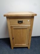 A contemporary oak cupboard fitted a drawer