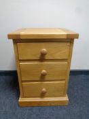 A contemporary oak three drawer bedside chest