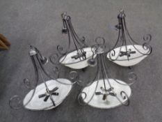 Four contemporary wrought iron hanging light fittings with opaque glass shades