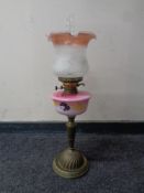 An antique brass oil lamp with hand painted glass reservoir,